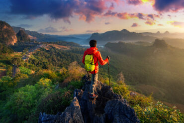 Backpacker watching sunrise over valleys and hills in Himachal.
