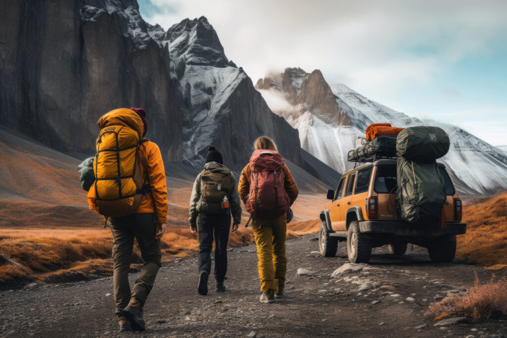 Group of trekkers with backpacks and an off-road car in Himachal mountains.