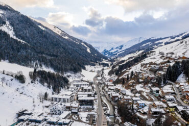 Snow-covered mountain town with winding roads and alpine houses, showcasing a scenic winter travel destination promoted by a travel agent in Manali.